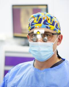 Dr n. med. Michał Czarnowski, ekspert implantologii i chirurgii stomatologicznej w CZAR-DENT, podczas precyzyjnego zabiegu z wykorzystaniem lup powiększających.