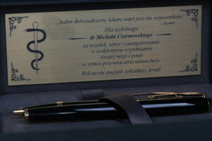 Eleganckie pióro wieczne z wygrawerowanym cytatem z Homera: „jeden doświadczony lekarz wart jest stu wojowników”, wręczone dr. n. med. Michałowi Czarnowskiemu. Wyjątkowy dowód zaufania i wdzięczności Pacjenta po udanym zakończeniu zaawansowanego leczenia implantologicznego i oddaniu ostatecznej pracy cyfrowej z laboratorium CZAR-LAB.